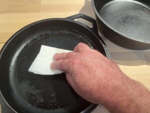 Applying oil to a camp oven to season it.