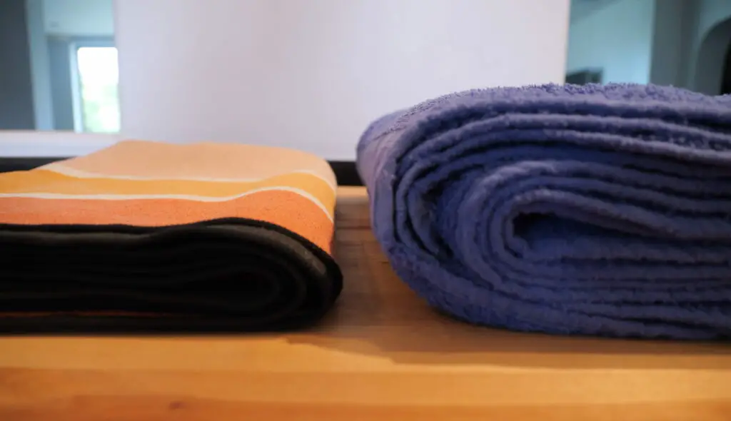 Folded Nomadix towel next to a folded cotton towel.