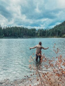 Wading into a lake to fish for trout